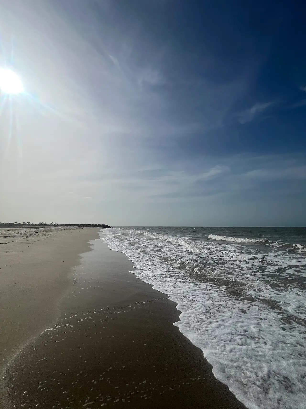 Orilla de la playa de Mayapo con olas suaves y el sol de la mañana