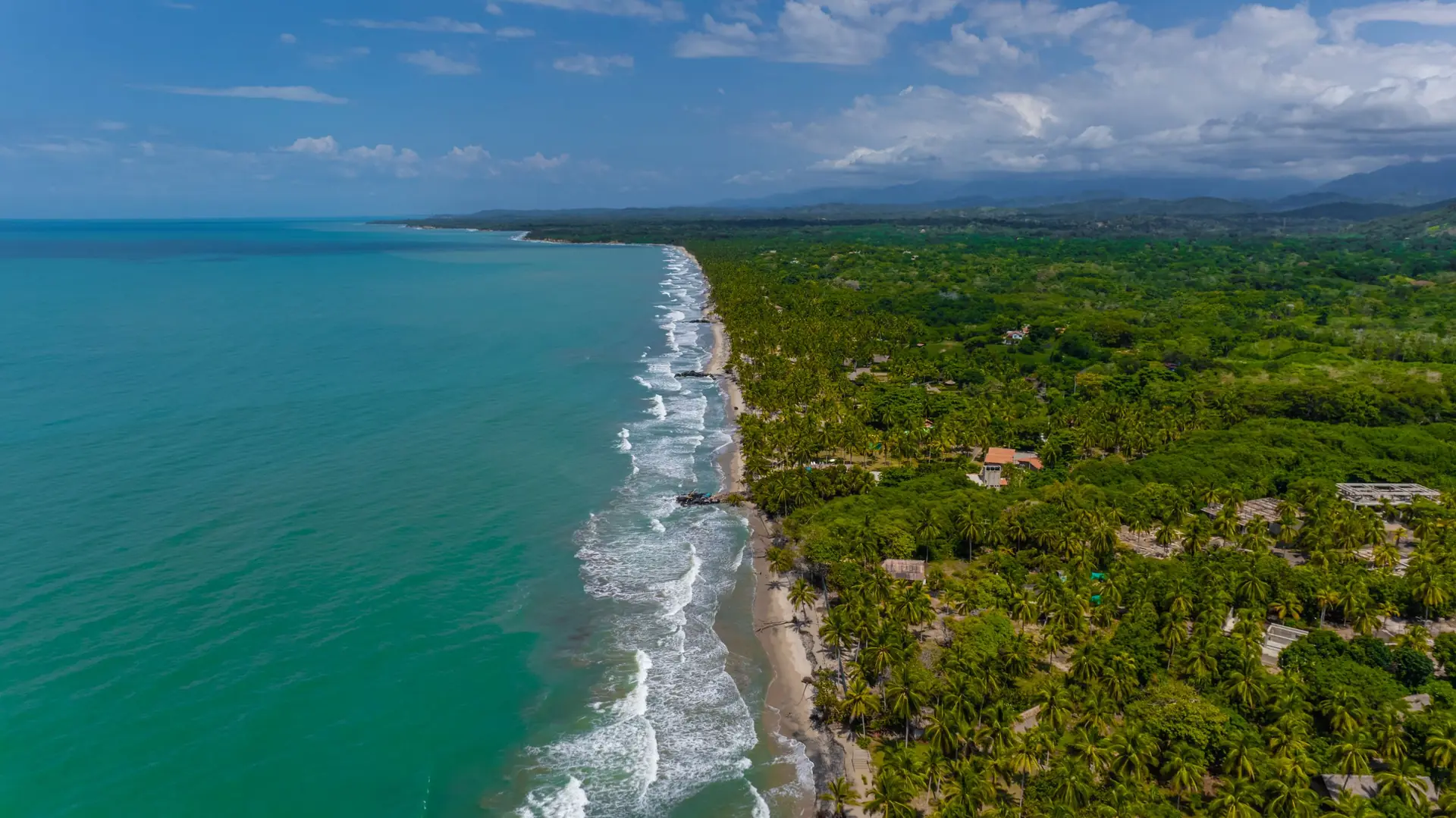 Vista aérea de la costa de Palomino: mar turquesa, playa y vegetación hasta la Sierra Nevada