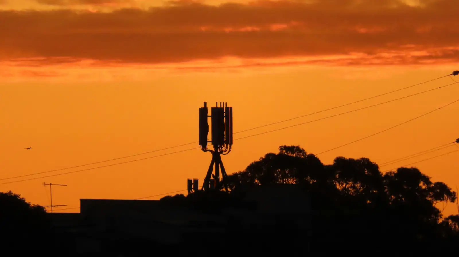 Silueta de una torre de telecomunicaciones al atardecer